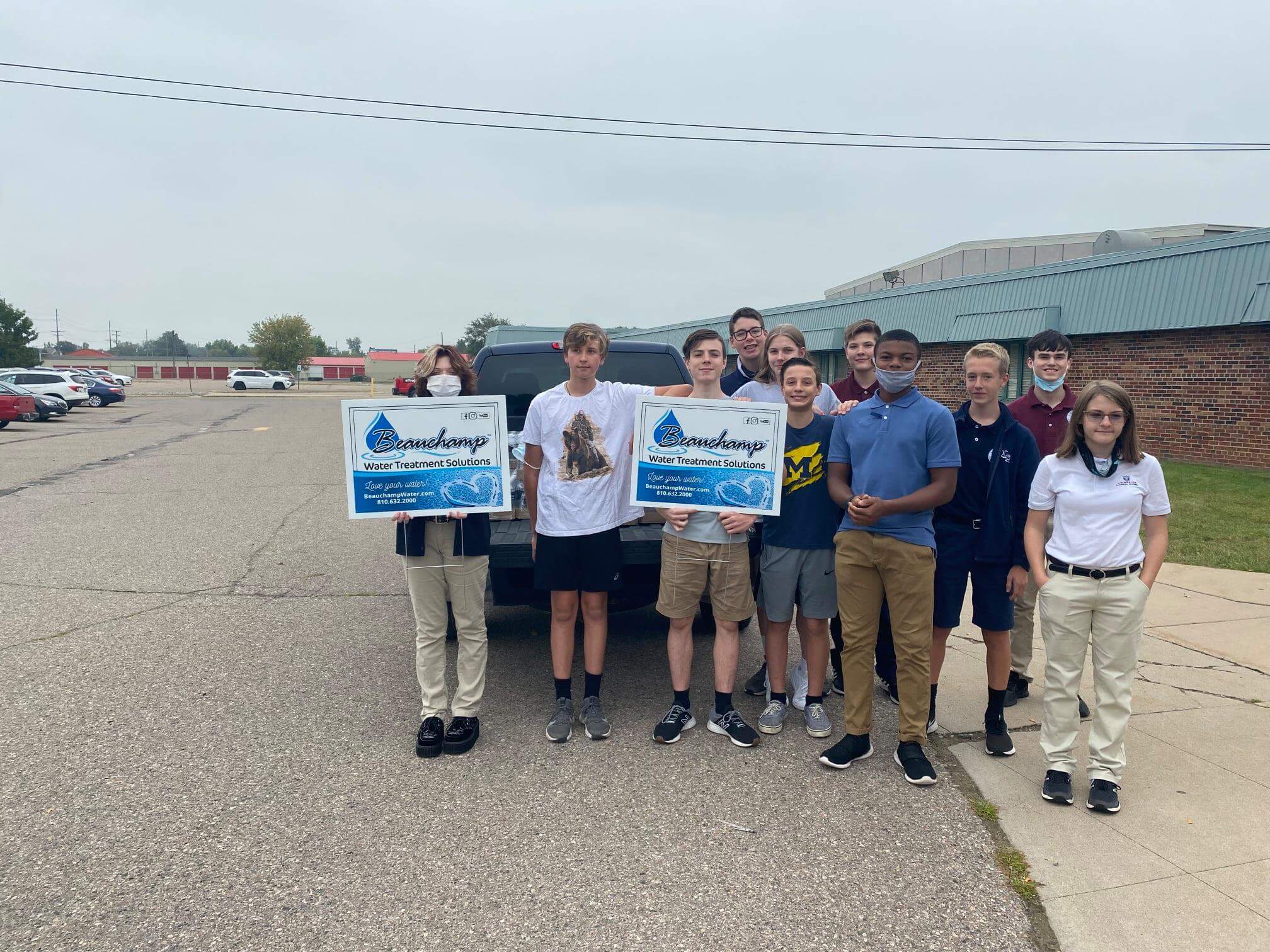 Students holding a sign to thank donor for thewater donation