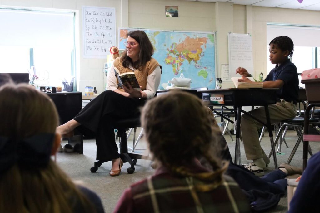 Engaging teacher reads to students in a bright, interactive classroom filled with learning resources.